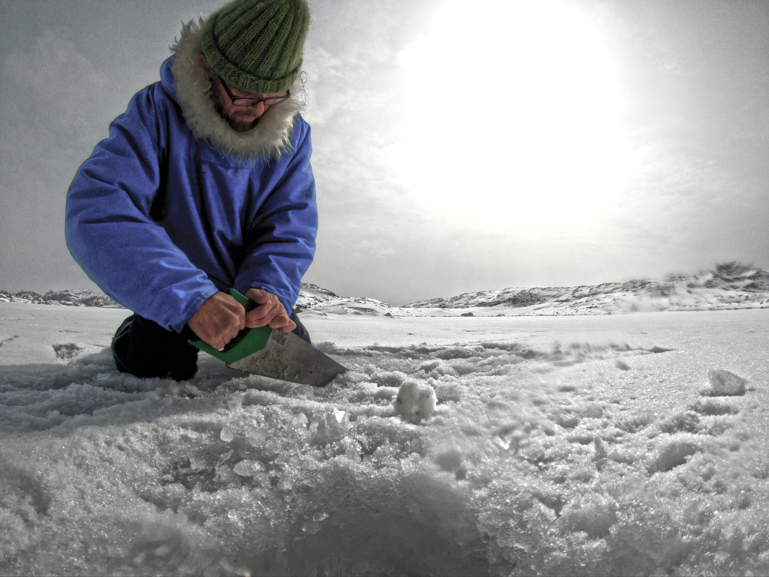 The artist saws through sea ice in a visual art work about climate change